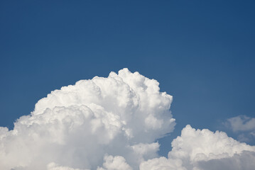 Big white fluffy clouds on clear blue sky. Cloudy sky background with copy space. Cumulus cloud close up