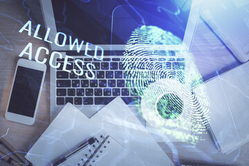 Finger print over computer on the desktop background. Top view. Double exposure. Concept of securitization.