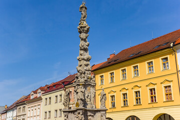 Fototapeta na wymiar Statues on the column in front of colorful houses in Kutna Hora, Czech Republic