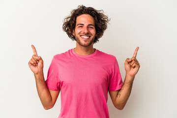 Young caucasian man isolated on white background indicates with both fore fingers up showing a...