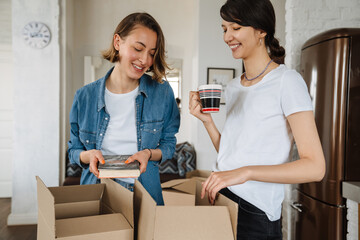 A smiling lesbian couple sorting boxes