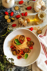 Fototapeta na wymiar Italian spaghetti with tomato, fried eggplant and bacon
