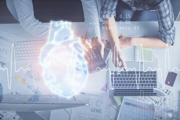 Double exposure of man and woman working together and heart hologram drawing. Computer background. Top View.