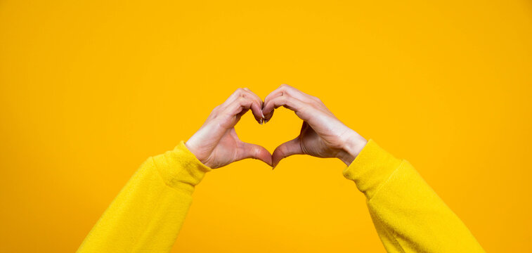 Hands Making Heart Shape Isolated On A Yellow Background - Love And Minimal Fashion Concept	
