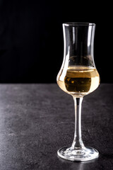 Italian golden grappa drink on black background	