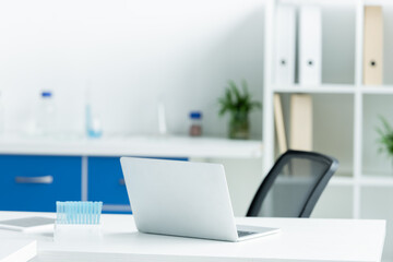 Laptop and test tubes on table in laboratory