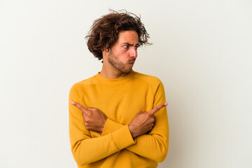 Young caucasian man isolated on white background points sideways, is trying to choose between two options.