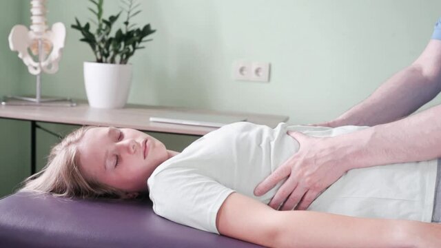 Myofascial Release of the tight Diaphragm, Osteopath practitioner using a prolonged, gradual stretch with two hands to release female patient diaphragm
