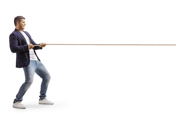 Full length profile shot of a young casual man pulling a rope