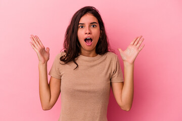 Young caucasian woman isolated on pink background celebrating a victory or success, he is surprised and shocked.