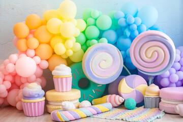 bright, colorful, rainbow photo zone. balloons, sweets, lollipops, caramel, macarons, cupcakes