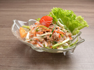 cold thai style spicy chilli sauce papaya and mango vegetable salad and shrimp in bowl on wood table asian Thai appetiser halal menu