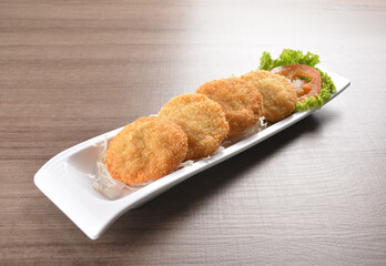 deep fried seafood crispy fish cake with spicy chilli sauce on wood table asian Thai appetiser halal menu