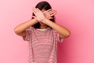 Young caucasian woman isolated on pink background keeping two arms crossed, denial concept.
