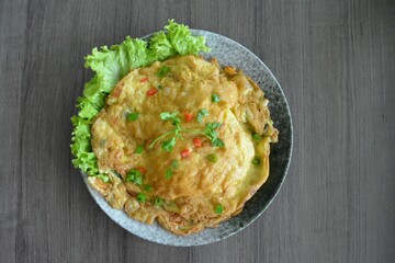 golden stir fried egg omelette with seafood and meat on wood table asian Thai appetiser halal menu