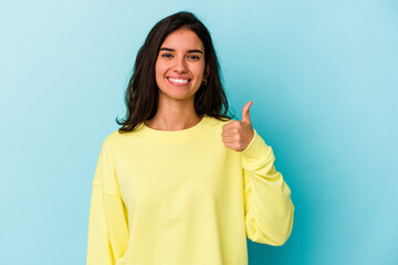 Young caucasian woman isolated on blue background smiling and raising thumb up