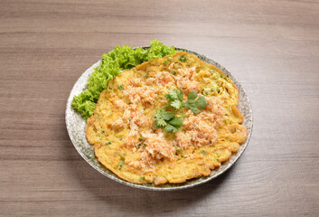 golden stir fried egg omelette with seafood and meat on wood table asian Thai appetiser halal menu