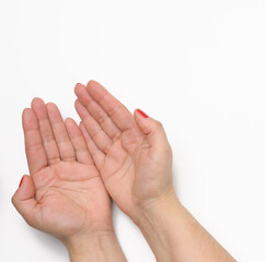 two female hands with red painted nails in a prayer pose on a white background