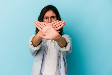 Young caucasian woman isolated on blue background doing a denial gesture