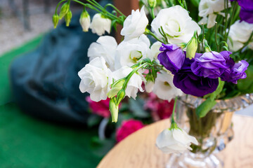 Bouquet of peony white roses in a vase on a table in a cafe