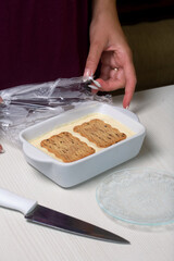 A woman removes the plastic from a container of homemade ice cream. Cookies and cream. Close-up shot.