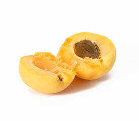 ripe yellow apricot broken in half on white background