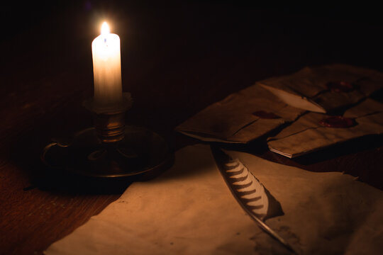 old letter with candle and feather