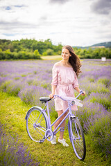 Woman in pink dress with retro bicycle in lavender field in Czech republic