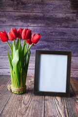 photo frame and tulip flower on table 