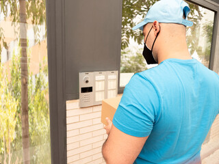 Caucasian man in uniform of postman or courier delivery man or parcels entering door and streets