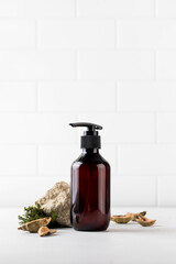 Organic cosmetic product in a brown dispenser surrounded by natural materials. An environmentally friendly product. 