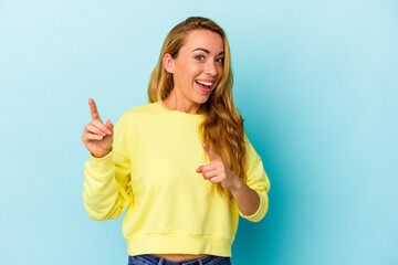 Caucasian woman isolated on blue background pointing to front with fingers.