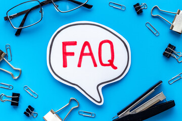 Text faq frequently asked questions on office table with stationery