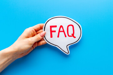Hands with faq word on paper bubble. Frequently asked questions concept