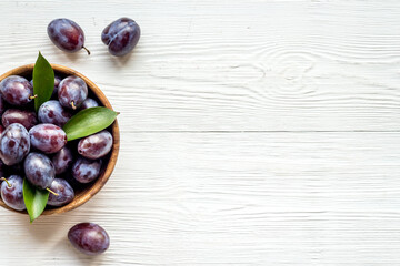 Purple plums in bowl. Plum harvest top view