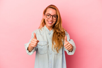 Caucasian blonde woman isolated on pink background smiling and raising thumb up