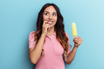 Young latin woman holding ice cream isolated on blue background relaxed thinking about something looking at a copy space.