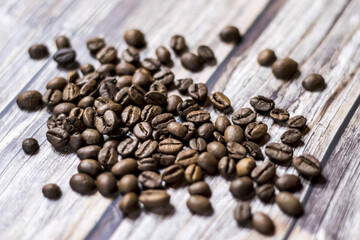 Close-up photo of scattered coffee beans on a wooden table