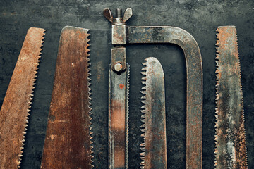 Saws on metal surface. Rusty tools for maintenance. Hardware to fix. Technical background