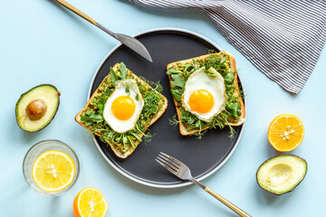 Eggs and avocado with spinach on toasted bread. Top view