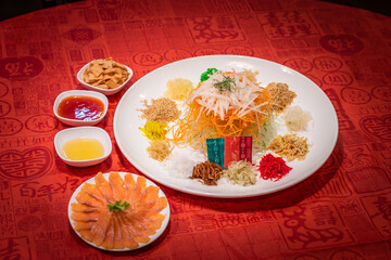 cny colourful smoked salmon yu sheng lo hei and sauces in red chinese new year background asian...