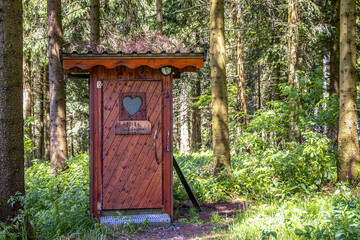Hütte mit Herzfenster im Wald