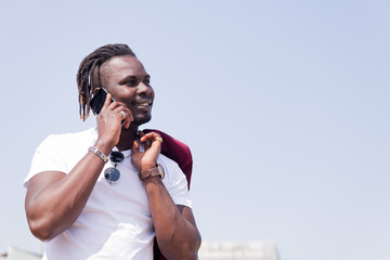 smiling black man talking by phone outdoors