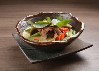 thai green curry hot spicy soup with beef or chicken with vegetables on wood background asian halal menu