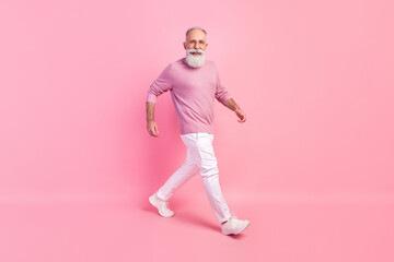 Photo of handsome attractive mature man dressed pullover glasses smiling walking isolated pink color background