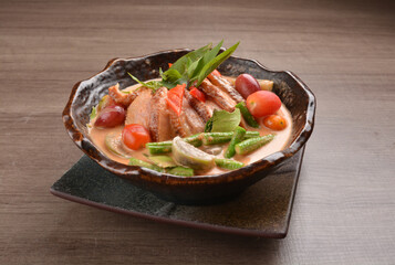thai red curry hot spicy soup with duck or chicken with vegetables on wood background asian halal menu