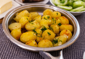 toasted young potatoes with dill in metal skillet