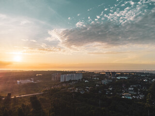 Aerial sunrise morning city. Multistory and small buildings in greenery with fog at dawn in nice pastel light. View on Sokilnyky district with bridge across Sarzhyn Yar in Kharkiv city.