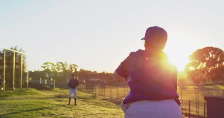 Diverse group of female baseball players practicing on pitch, throwing and catching ball - Powered by Adobe