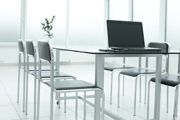 Laptop on glass table in spacious office space